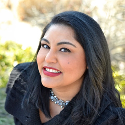 Smiling woman outdoors in sunlight.