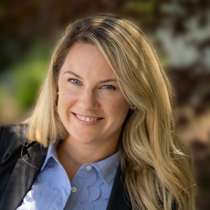 Smiling woman outdoors in sunlight.